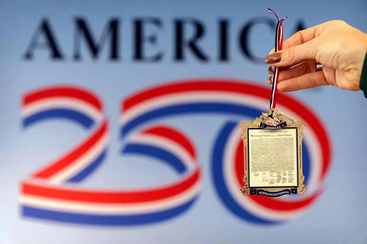 Jennifer Condon, Executive Vice President of America250, displays the front of a commemorative ornament released by America250 as part of events leading up to the 250th anniversary of the signing of the Declaration of Independence in 1776, is photographed Thursday, Nov. 13, 2025, in Washington. (AP Photo/Mark Schiefelbein)