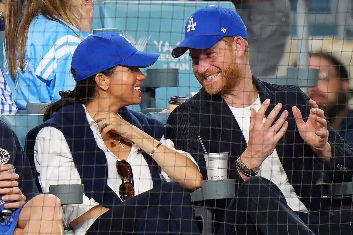 Prince Harry, right, and Meghan Markle, Duke and Duchess of Sussex, sit during the eighth inning in Game 4 of baseball's World Series between the Los Angeles Dodgers and the Toronto Blue Jays in Los Angeles, Tuesday, Oct. 28, 2025. (Frank Gunn/The Canadian Press via AP)