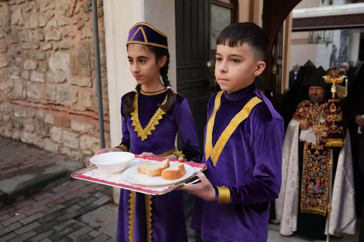 Children and Armenian Patriarch of Constantinople Archbishop Sahag II Mashalian, background right, wait for Pope Leo XIV to celebrate a liturgy at the Armenian Apostolic Cathedral, in Istanbul, Turkey, Sunday, Nov. 30, 2025. (AP Photo/Dilara Acikgoz)