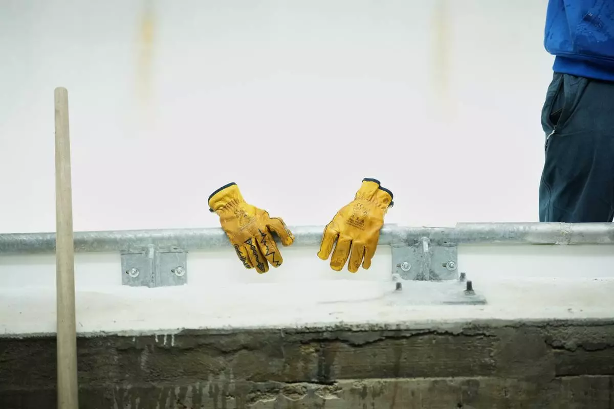 A worker's gloves and tool are lined up along the track ahead of a three-day skeleton and bobsled World Cup stage and Olympic test event in Cortina D'Ampezzo, Italy, Wednesday, Nov. 19, 2025. (AP Photo/Andrew Medichini)