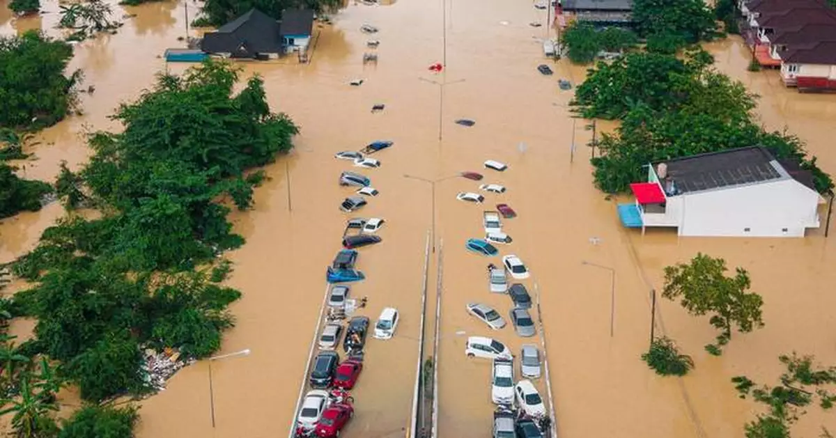 Families in southern Thailand perch on rooftops to escape flooding that has killed at least 33