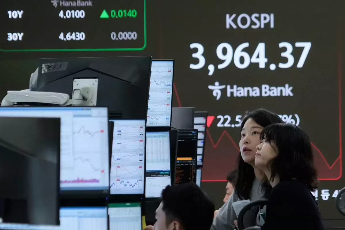 Currency traders watch monitors near a screen showing the Korea Composite Stock Price Index (KOSPI) at the foreign exchange dealing room of the Hana Bank headquarters in Seoul, South Korea, Friday, Nov. 28, 2025. (AP Photo/Ahn Young-joon)