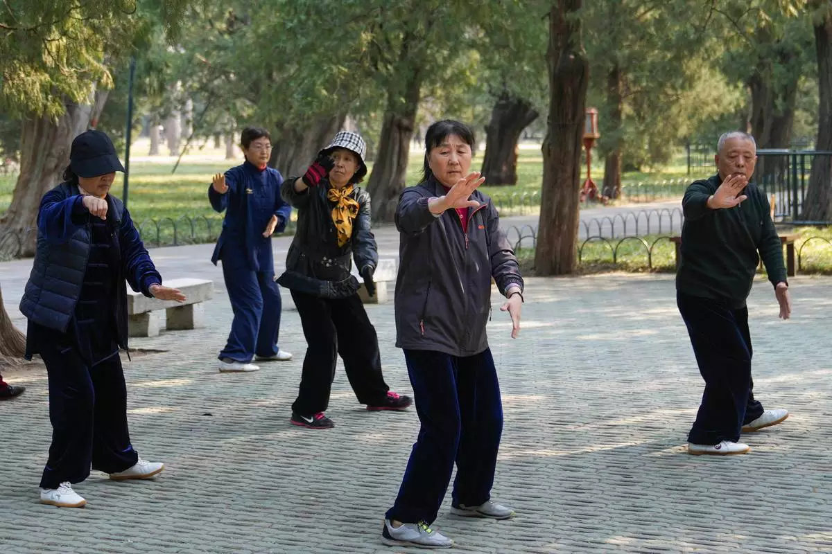 FILE - People exercise at a park near the Temple of Heaven in Beijing on April 2, 2024.(AP Photo/Tatan Syuflana, File)