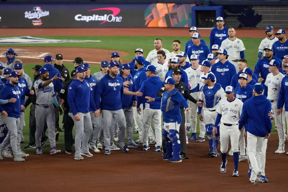 The Los Angeles Dodgers and the Toronto Blue Jays benches clear after Blue Jays' Andrés Giménez was hit by a pitch during the fourth inning in Game 7 of baseball's World Series, Saturday, Nov. 1, 2025, in Toronto. (AP Photo/Ashley Landis)