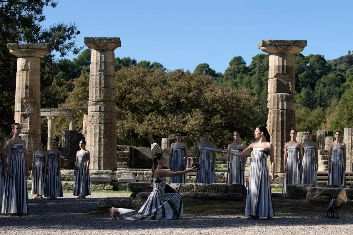 Actor Mary Mina playing the role of high priestess, right, performs during a rehearsal ahead of the flame lighting for the Milan Cortina 2026 Winter Olympics, at the Ancient Olympia site, Greece, Monday, Nov. 24, 2025. (AP Photo/Thanassis Stavrakis)