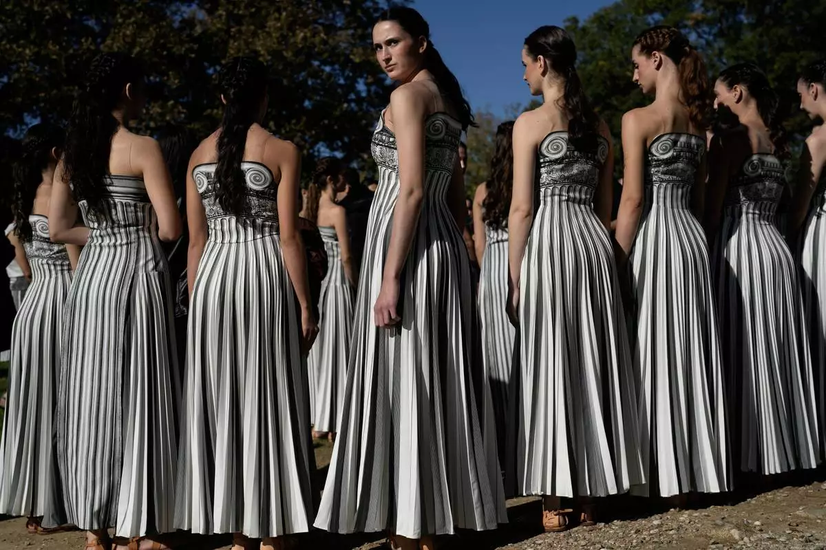 Performers playing the role of priestesses wait for the start of a rehearsal ahead of the flame lighting for the Milan Cortina 2026 Winter Olympics, at the Ancient Olympia site, Greece, Monday, Nov. 24, 2025. (AP Photo/Petros Giannakouris)