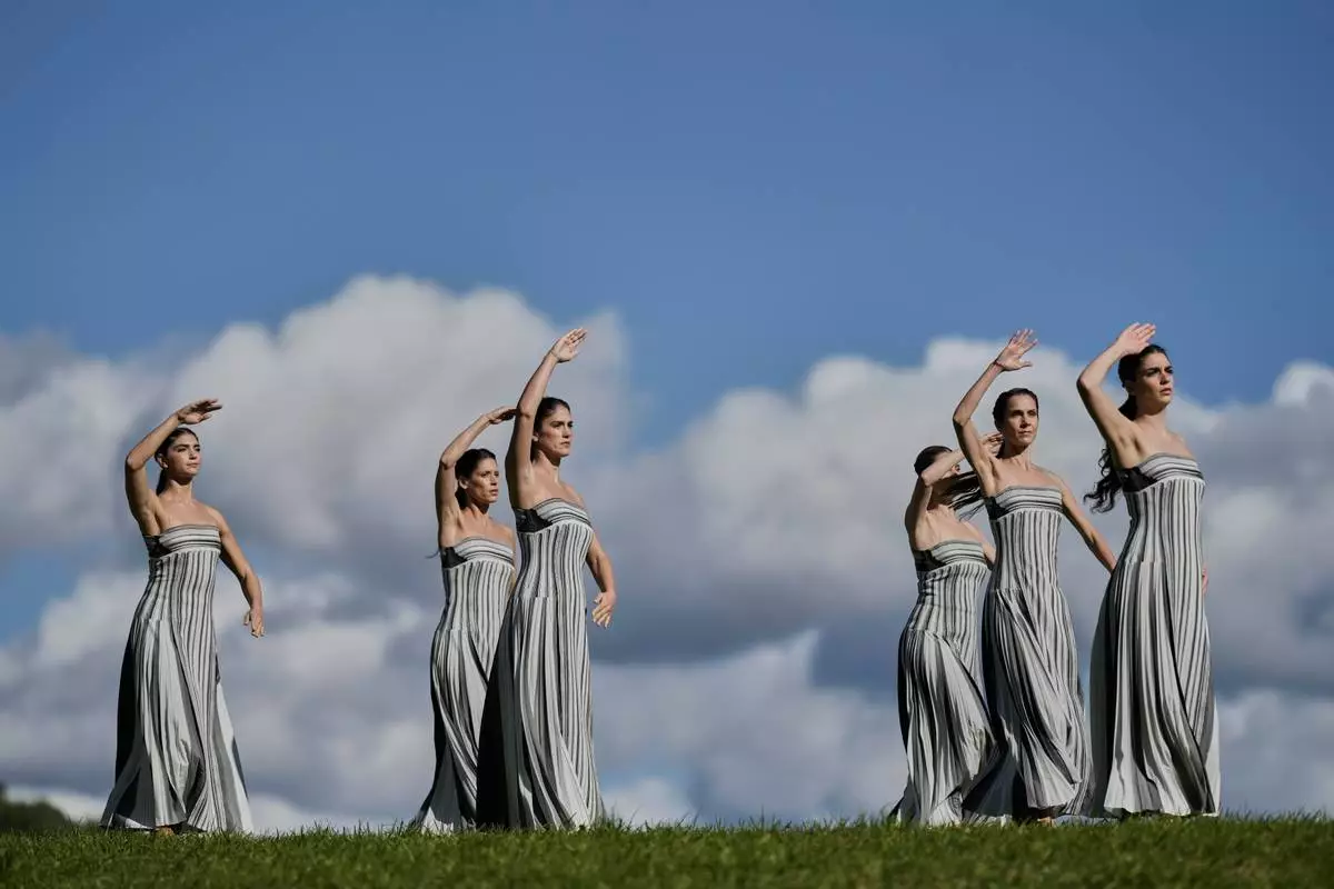 Dancers playing the role of priestesses perform during a rehearsal ahead of the flame lighting for the Milan Cortina 2026 Winter Olympics, at the Ancient Olympia site, Greece, Monday, Nov. 24, 2025. (AP Photo/Petros Giannakouris)