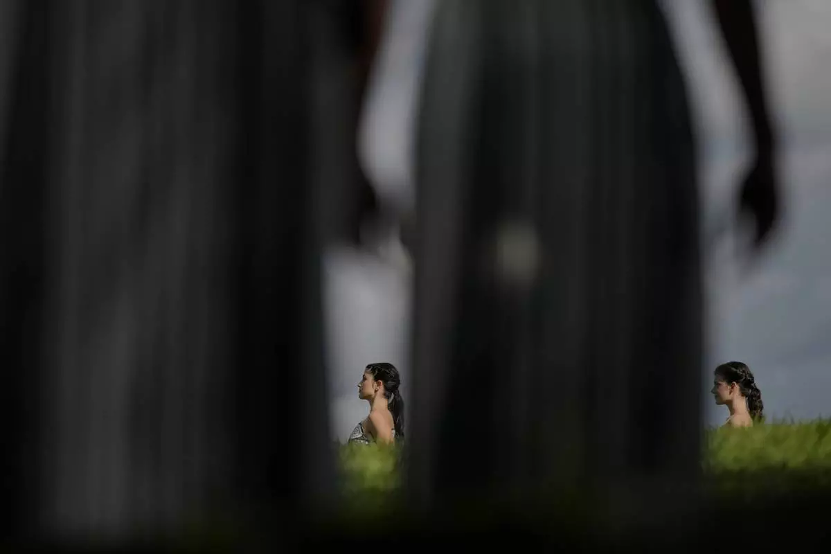 Dancers playing the role of priestesses perform during a rehearsal ahead of the flame lighting for the Milan Cortina 2026 Winter Olympics, at the Ancient Olympia site, Greece, Monday, Nov. 24, 2025. (AP Photo/Petros Giannakouris)