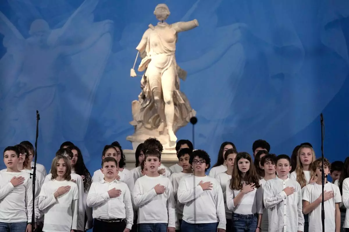 The children's choir of the Italian School of Athens sing the national anthem during the flame lighting ceremony for the Milan Cortina 2026 Winter Olympics, at the archaeological museum of Olympia, Greece, Wednesday, Nov. 26, 2025. (AP Photo/Thanassis Stavrakis)