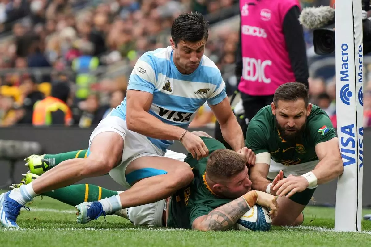 FILE -South Africa's Malcolm Marx, center, scores a try during the Rugby Championship match between Argentina and South Africa at Twickenham stadium, in London, Oct. 4, 2025. (AP Photo/Alastair Grant, File)