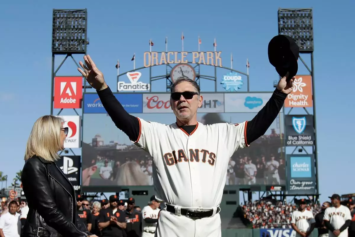 FILE - San Francisco Giants manager Bruce Bochy, center, gestures toward fans next to his wife Kim during a ceremony honoring Bochy after a baseball game between the Giants and the Los Angeles Dodgers in San Francisco, Sept. 29, 2019. (AP Photo/Jeff Chiu, Pool, File)