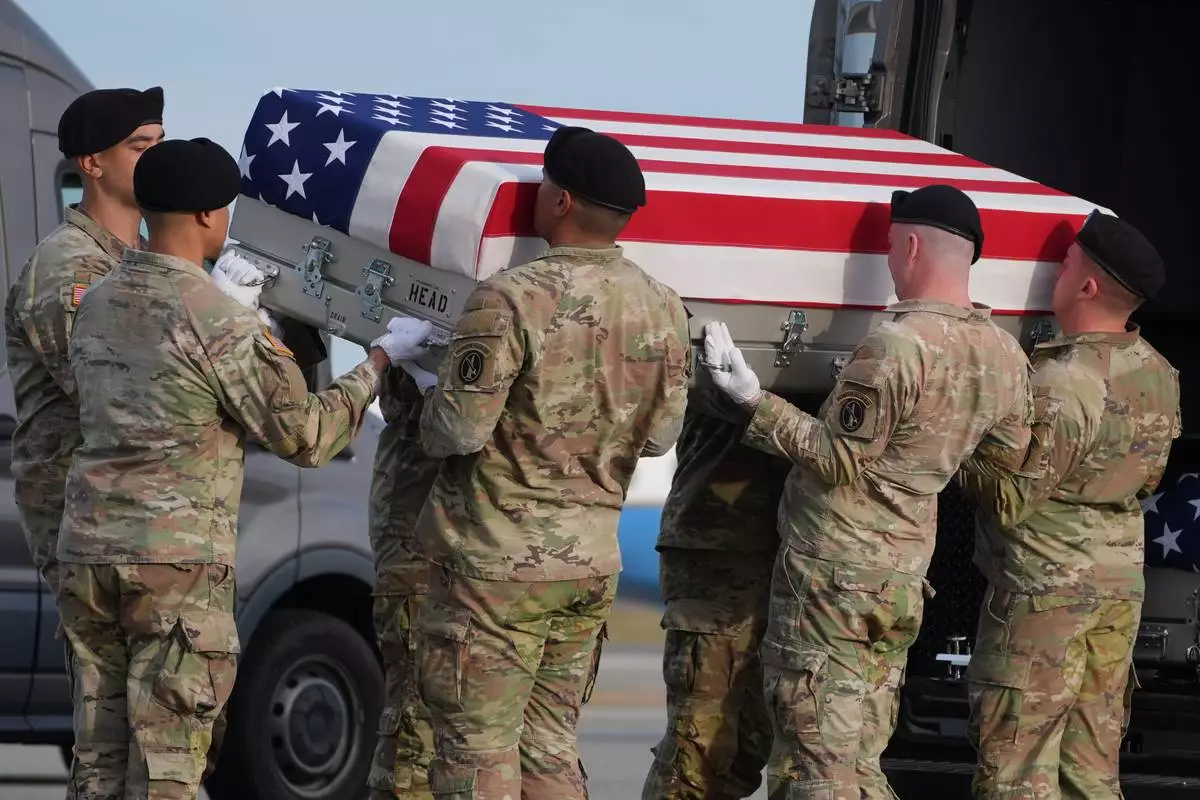 An Army carry team places the flag-draped transfer case with the remains of civilian interpreter Ayad Mansoor Sakat of Macomb, Mich., into the transfer vehicle during a casualty return, Wednesday, Dec. 17, 2025, at Dover Air Force Base, Del. (AP Photo/Evan Vucci)