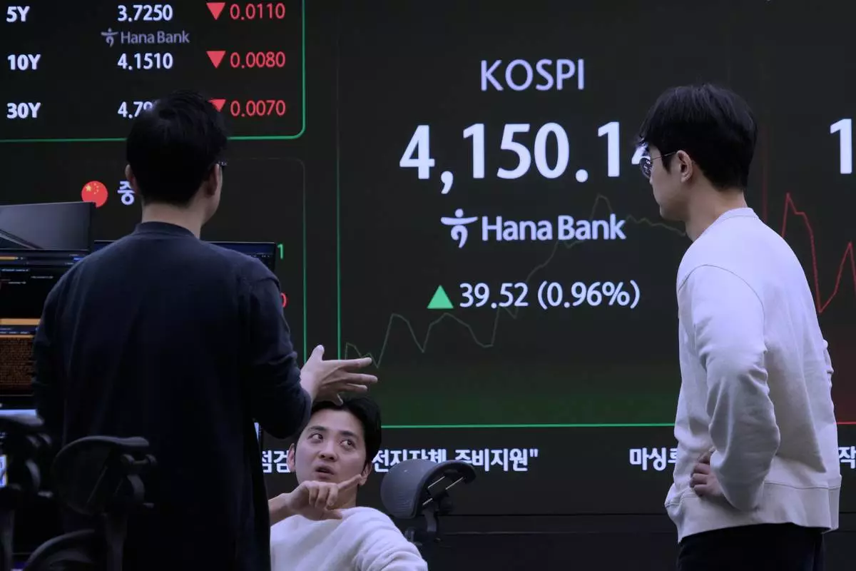 Currency traders work near a screen showing the Korea Composite Stock Price Index (KOSPI) at the foreign exchange dealing room of the Hana Bank headquarters in Seoul, South Korea, Friday, Dec. 12, 2025. (AP Photo/Ahn Young-joon)