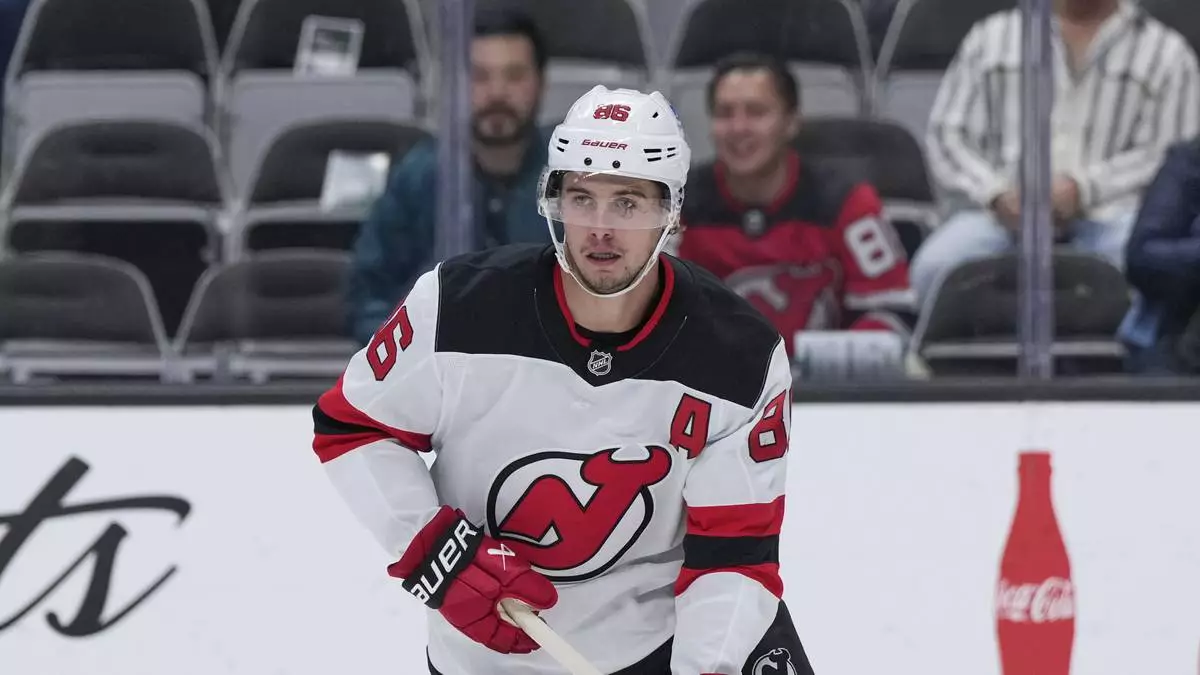 FILE - New Jersey Devils center Jack Hughes moves the puck during the first period of an NHL hockey game against the San Jose Sharks, Oct. 30, 2025, in San Jose, Calif. (AP Photo/Godofredo A. Vásquez, file)