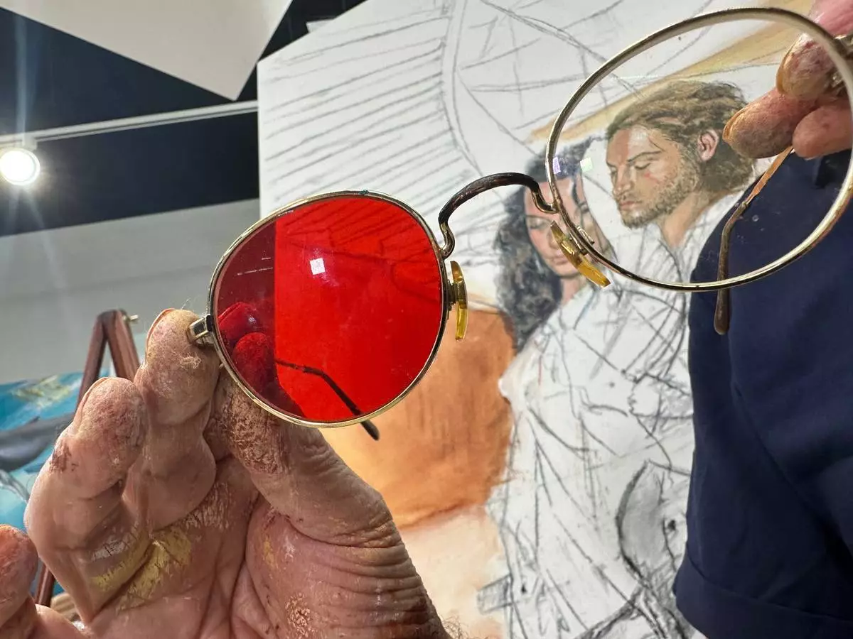 Fernando Dávila, a colorblind painter, shows his glasses designed to help see color at his gallery in Doral, Fla. on Thursday, Dec. 18, 2025. (AP Photo/Cody Jackson)