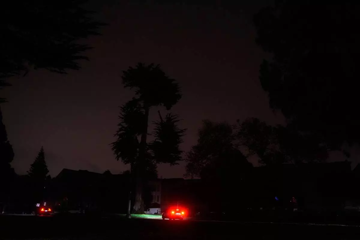 The taillights from a vehicle are shown as power outages darken the streets, in San Francisco, Saturday, Dec. 20, 2025. (AP Photo/Jeff Chiu)