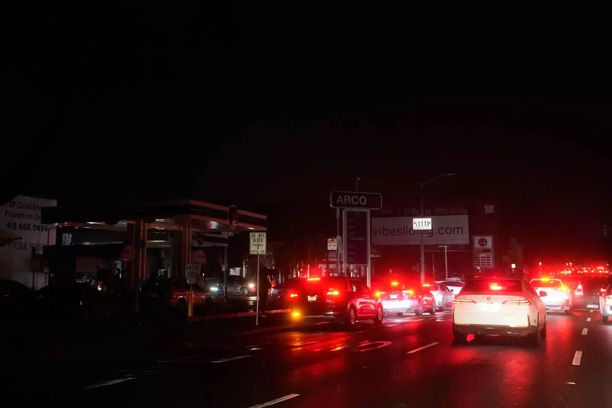Cars wait at an intersection with no working traffic lights from power outages, in San Francisco, Saturday, Dec. 20, 2025. (AP Photo/Jeff Chiu)