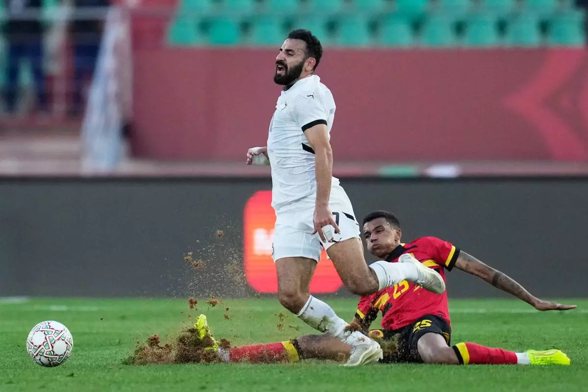 Egypt's Mohanad Lasheen is challenged by Angola's Randy Nteka during the Africa Cup of Nations group B soccer match between Angola and Egypt in Agadir, Morocco, Monday, Dec. 29, 2025. (AP Photo/Mosa'ab Elshamy)