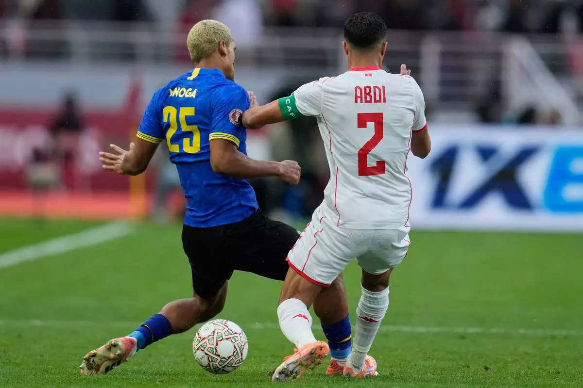Tanzania's Haji Mnoga, left, and Tunisia's Ali Abdi compete for the ball during the Africa Cup of Nations group C soccer match between Tanzania and Tunisia in Rabat, Morocco, Tuesday, Dec. 30, 2025. (AP Photo/Mosa'ab Elshamy)