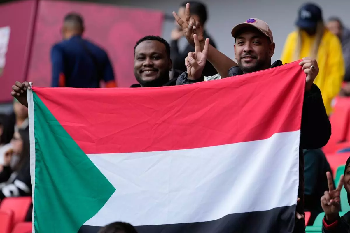 Sudan fans hold their national flag ahead of the Africa Cup of Nations group E soccer match between Algeria and Sudan in Rabat, Morocco, Wednesday, Dec. 24, 2025. (AP Photo/Mosa'ab Elshamy)