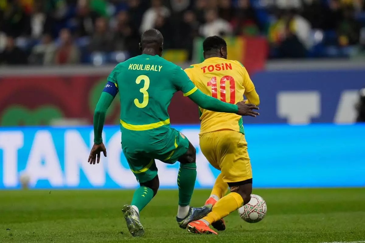 Senegal's Kalidou Koulibaly, left, makes a tackle on Benin's Aiyegun Tosin during the Africa Cup of Nations group D soccer match between Benin and Senegal in Tangier, Morocco, Tuesday, Dec. 30, 2025. (AP Photo/Themba Hadebe)