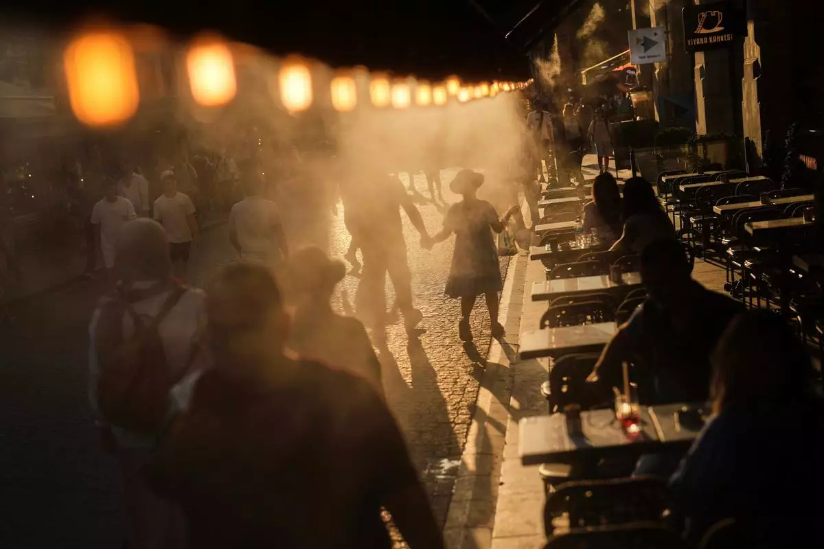 A coffee bar in Istanbul sprays mist to cool people passing by on July 24, 2025. (AP Photo/Francisco Seco, File)