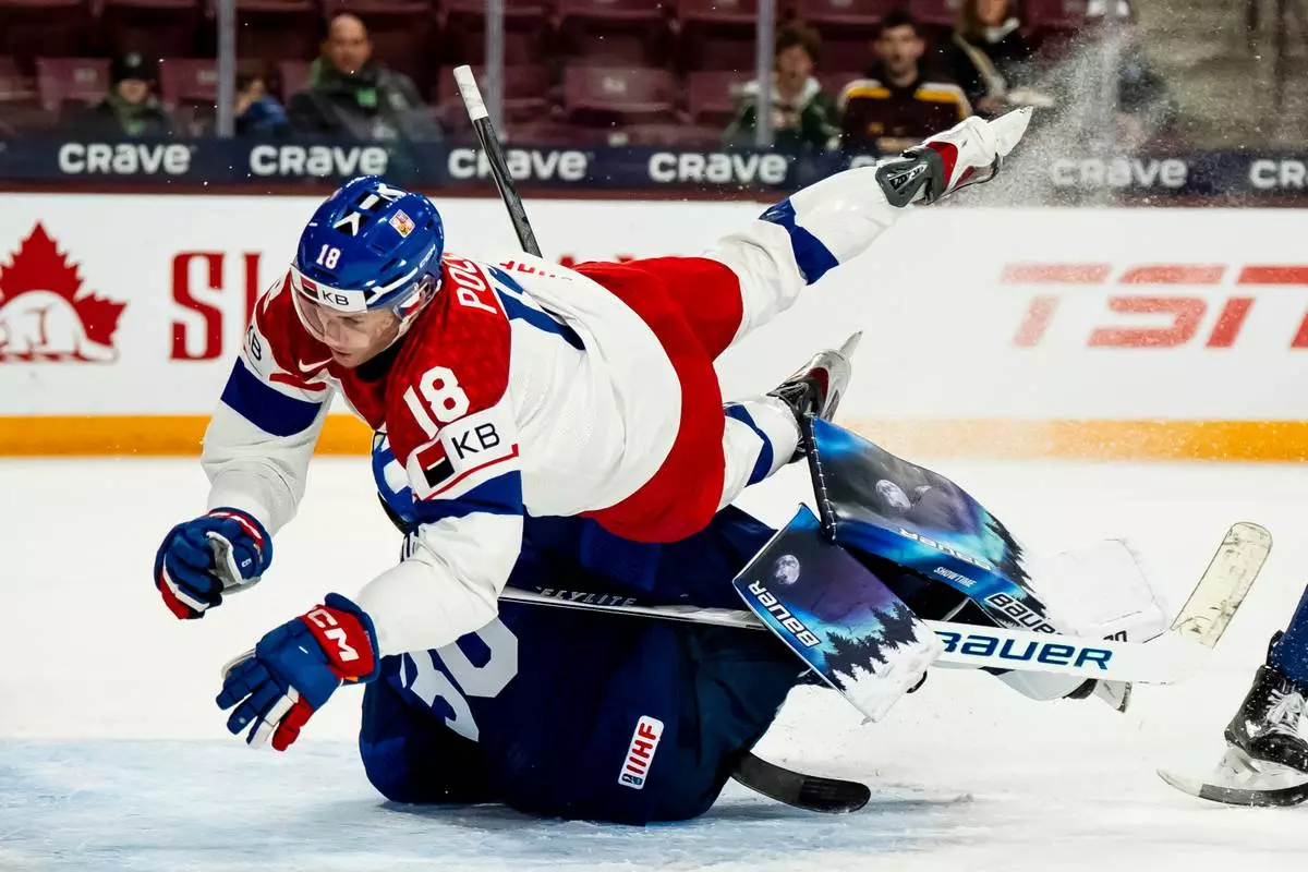 Czechia's Tomas Poletin (18) collides with Finland goaltender Petteri Rimpinen (30) during first period match at the world junior hockey championship in Minneapolis, Monday, Dec. 29, 2025. (Christopher Katsarov/The Canadian Press via AP)
