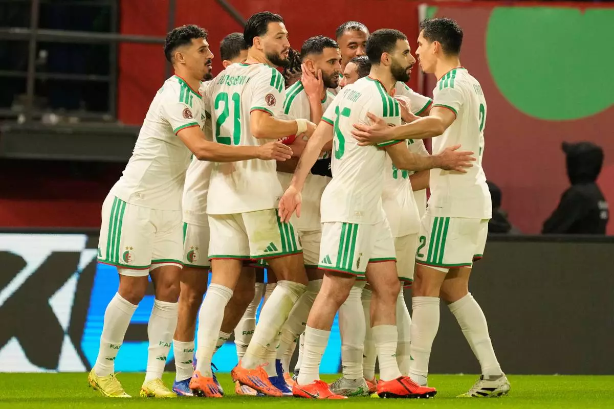 Algeria's Riyad Karim Mahrez, center, celebrates with his teammates after scoring his side's first goal during the Africa Cup of Nations group E soccer match between Algeria and Burkina Faso in Fez, Morocco, Sunday, Dec. 28, 2025. (AP Photo/Mosa'ab Elshamy)