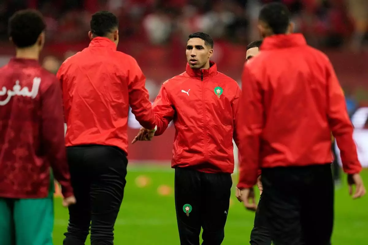 Morocco's Achraf Hakimi shakes hands with teammates ahead of the African Cup of Nations Group A soccer match between Morocco and Mali in Rabat, Morocco, Friday, 26, 2025. (AP Photo/Mosa'ab Elshamy)