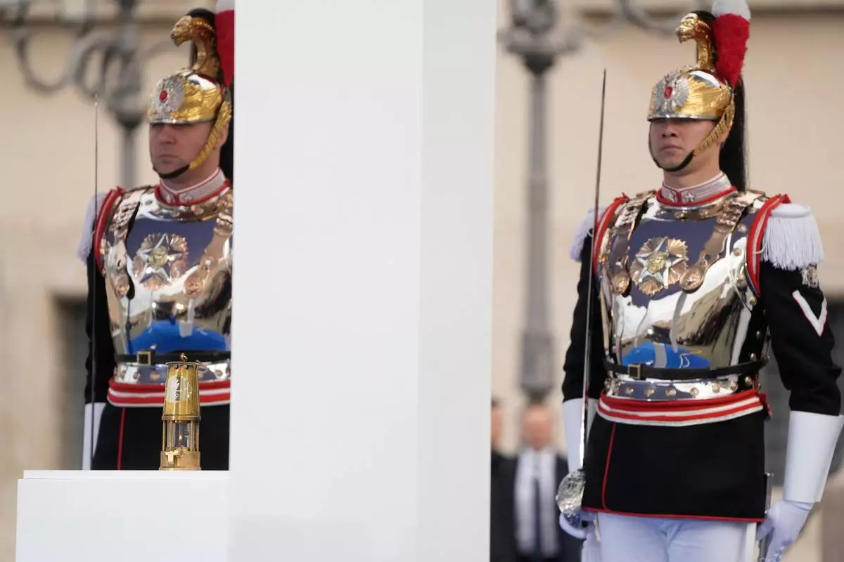 Cuirassiers stand next to the torch lantern prior to the Milan Cortina 2026 Winter Olympics cauldron lighting, in front of the Quirinale Presidential Palace, in Rome, Friday Dec. 5, 2025. (AP Photo/Gregorio Borgia)