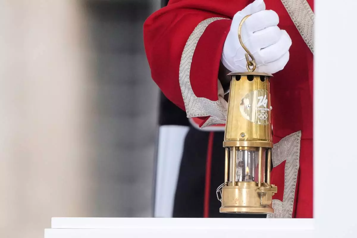 A cuirassier holds the torch lantern prior to the Milan Cortina 2026 Winter Olympics cauldron lighting, in front of the Quirinale Presidential Palace, in Rome, Friday Dec. 5, 2025. (AP Photo/Gregorio Borgia)