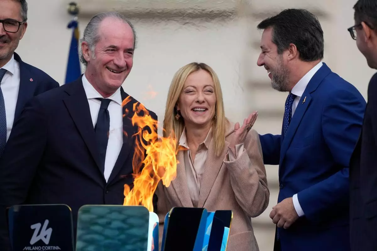 Italy's Prime Minister Giorgia Meloni, center is flanked by Veneto region President Luca Zaia, left, and vice president of Italy's Council of Ministers Matteo Salvini attend the Milan Cortina 2026 Winter Olympics cauldron lighting, in front of the Quirinale Presidential Palace, in Rome, Friday Dec. 5, 2025. (AP Photo/Gregorio Borgia)