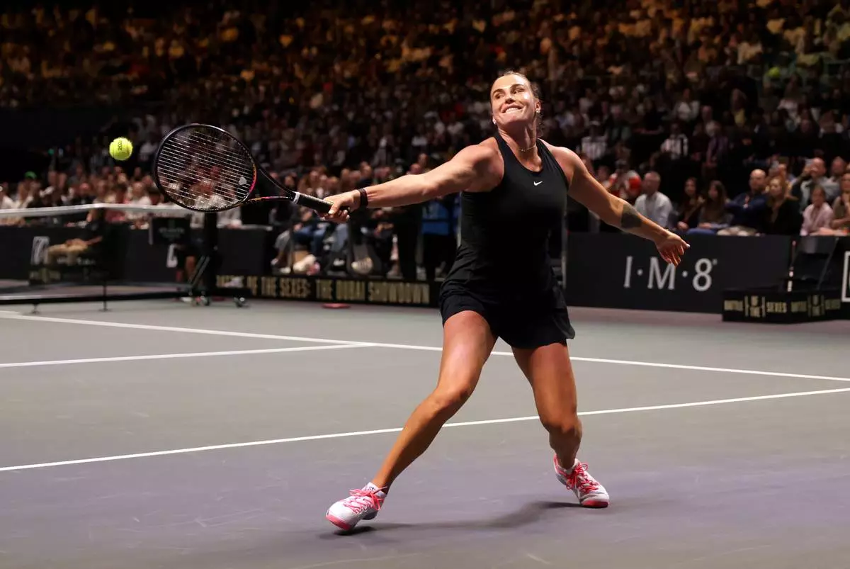 Aryna Sabalenka returns the ball to Nick Kyrgios during their Battle of the Sexes match in Dubai, United Arab Emirates, Sunday Dec. 28, 2025. (Christopher Pike/Pool Photo via AP)