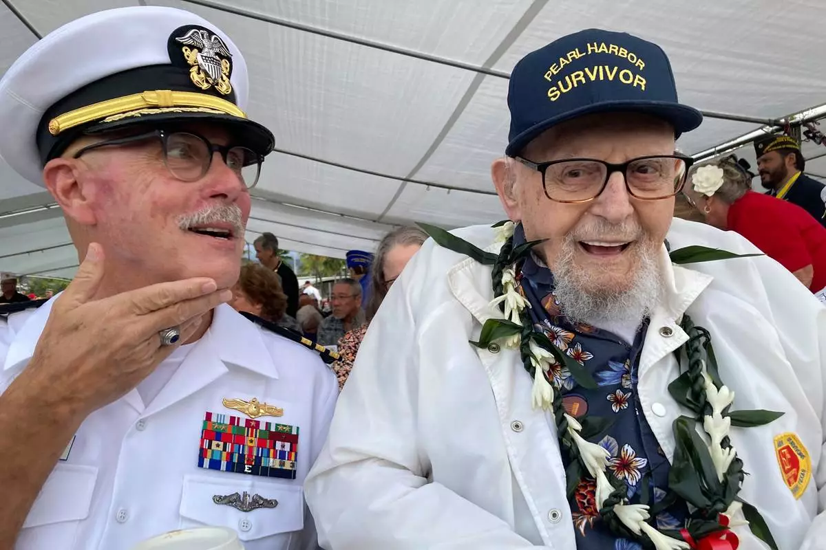FILE - Ira Schab, right, who survived the attack on Pearl Harbor as a sailor on the USS Dobbin, talks with reporters while sitting next to his son, retired Navy Cmdr. Karl Schab, on Dec. 7, 2022, in Pearl Harbor, Hawaii. (AP Photo/Audrey McAvoy, File)