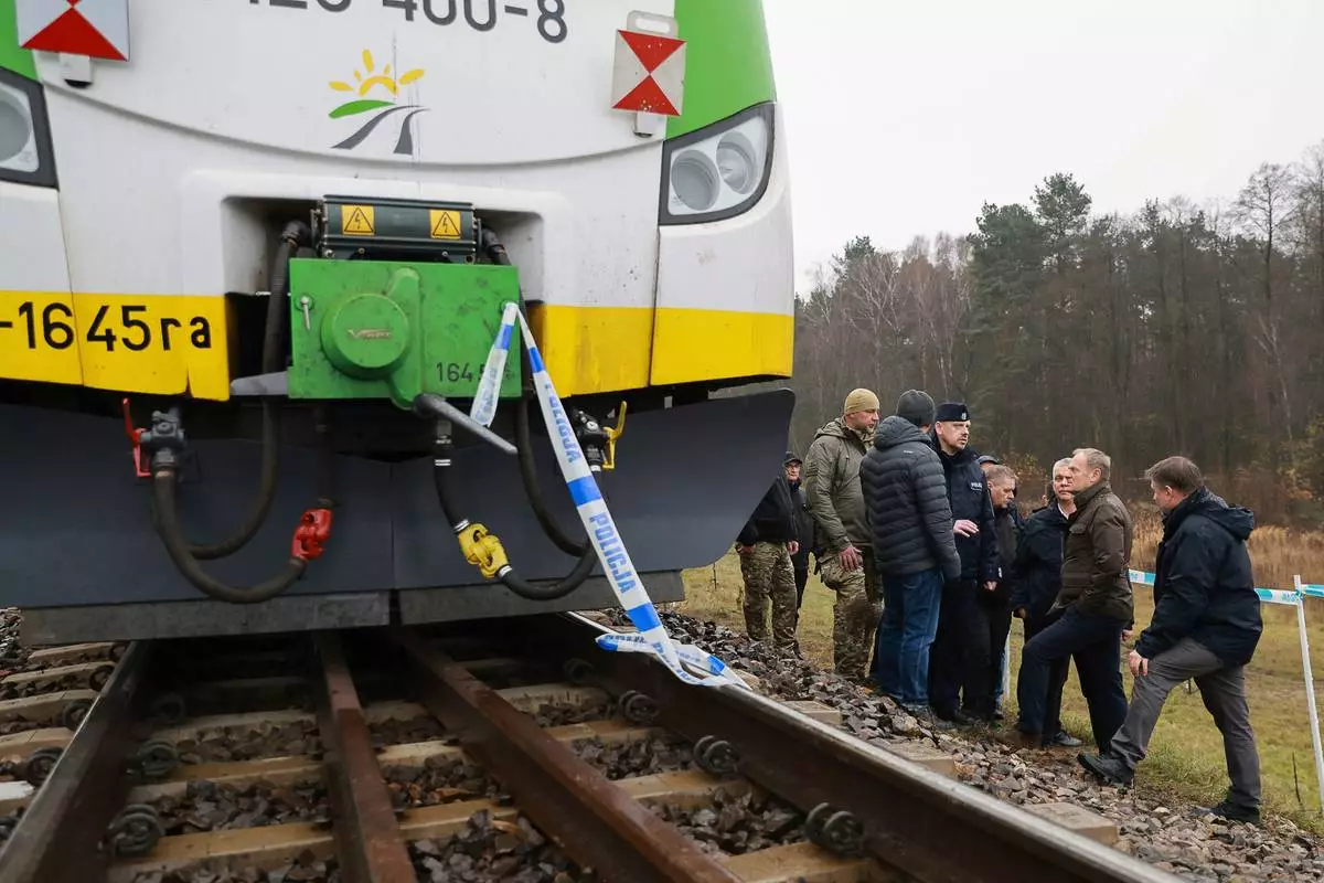 FILE - Polish Prime Minister Donald Tusk, second right, visits the sabotaged rail line near Mika, Poland, Nov. 17, 2025. (AP Photo/KPRM, File)