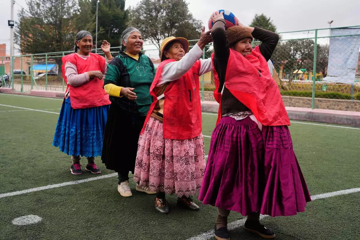 FILE - An Aymara grandmother passes the ball during a warm up before the start of a handball match in El Alto, Bolivia, Dec. 9, 2025. (AP Photo/Juan Karita, File)
