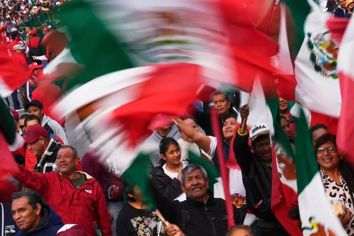 FILE - Supporters celebrate seven years of the Fourth Transformation movement, or 4T, initiated by former Mexican President Andrés Manuel López Obrador, in the Zócalo of Mexico City, Dec. 6, 2025. (AP Photo/Marco Ugarte, File)