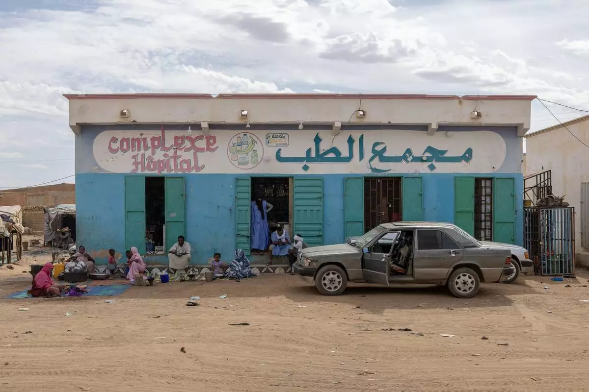 People who fled violence in Mali stand in front of the Bassikounou hospital in the Hodh El Chargui Region, where they found refuge in Mauritania, Nov. 7 2025. (AP Photo/Caitlin Kelly)