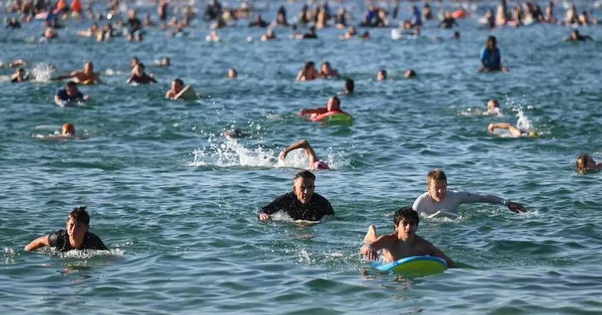 A sunrise crowd gathers at Bondi Beach in solace and defiance after a massacre