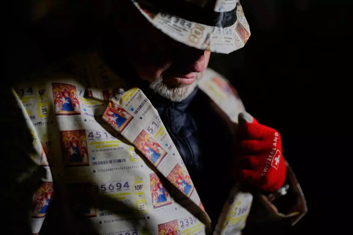 FILE - A spectator waits for the start of the annual Christmas lottery draw, known as El Gordo, or The Fat One, at Madrid's Teatro Real, Spain, Monday, Dec. 22, 2025. (AP Photo/Manu Fernandez, File)
