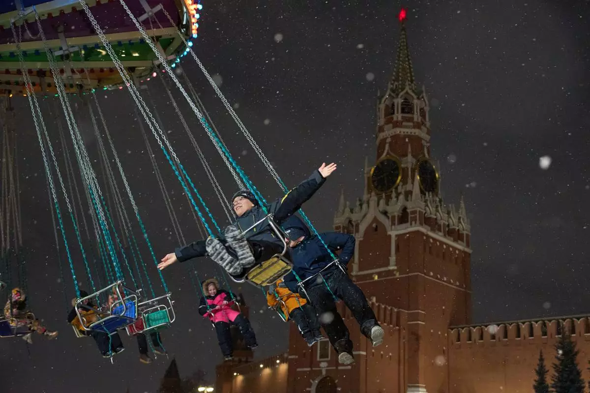 FILE - Children ride a carousel at the Christmas fair decorated for Christmas and the New Year festivities in Red Square in Moscow, Thursday, Dec. 25, 2025, with the Spasskaya Tower in the background. (AP Photo/Alexander Zemlianichenko, File)