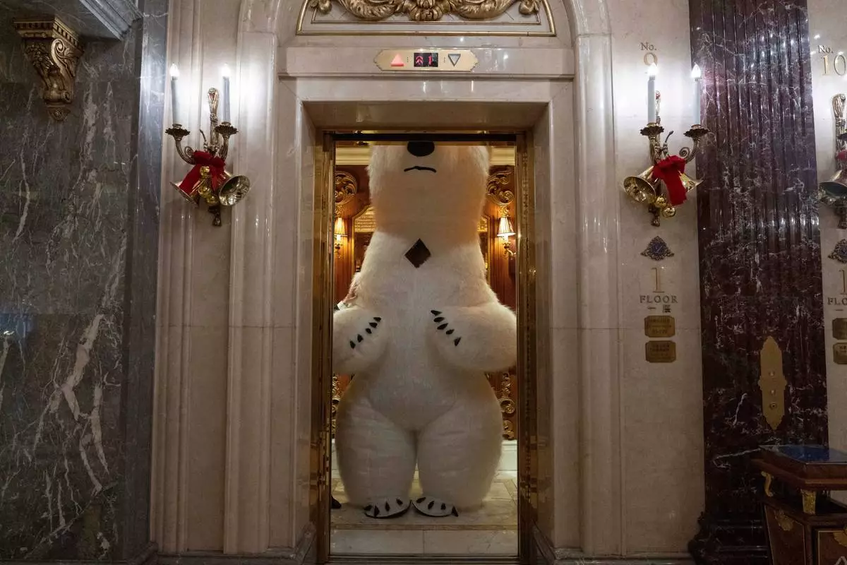 FILE - A polar bear mascot takes a ride in a lift during a break from entertaining guests on Christmas Eve in Beijing, Wednesday, Dec. 24, 2025. (AP Photo/Ng Han Guan, File)