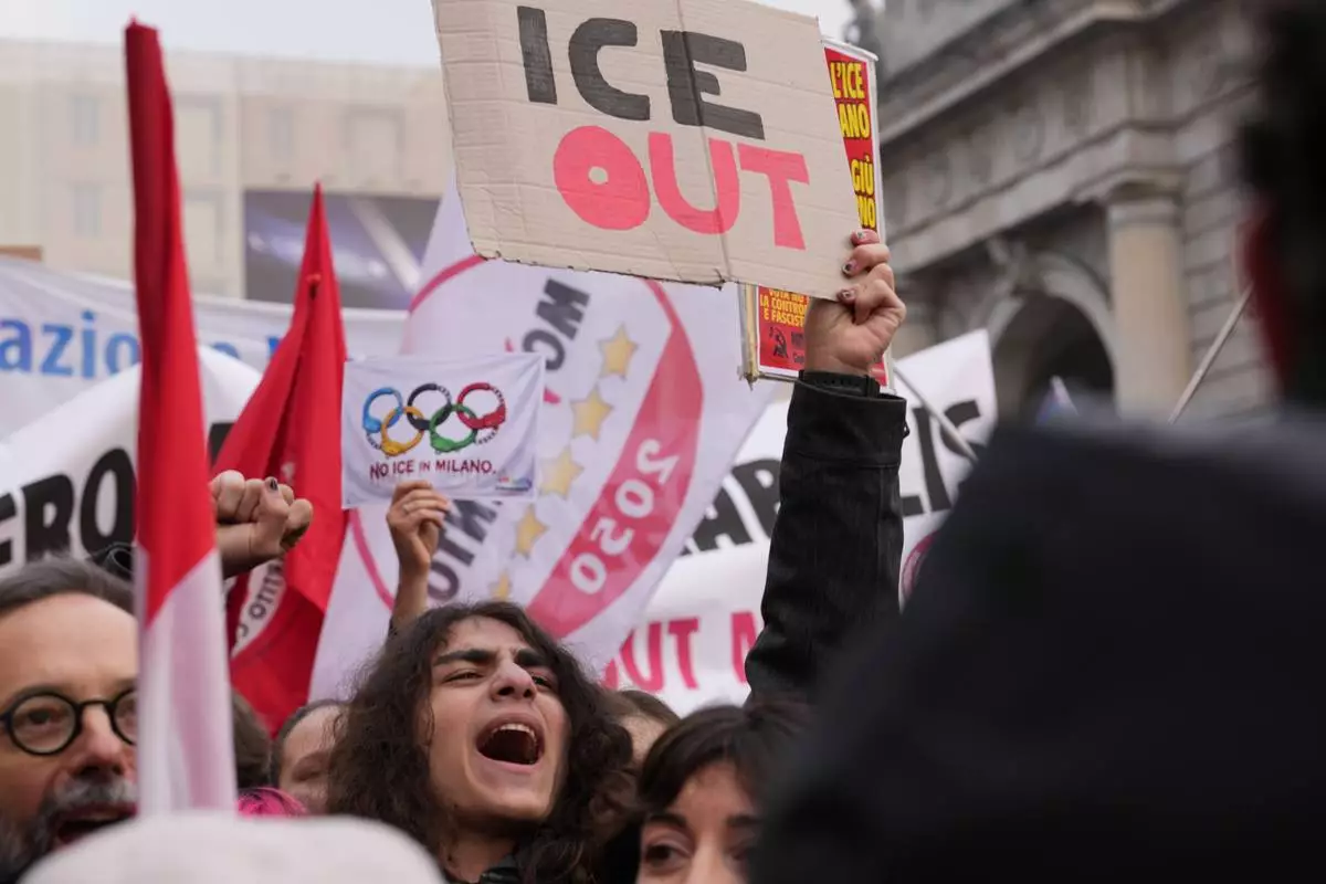 A person holds a sign, during an Anti-ICE demonstration, ahead of the 2026 Winter Olympics, in Milan, Italy, Saturday, Jan. 31, 2026. (AP Photo/Antonio Calanni)
