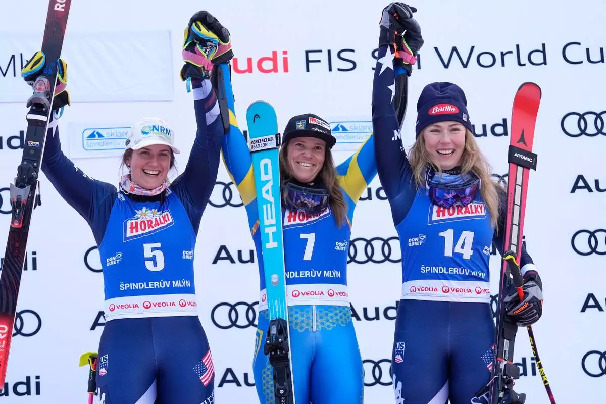 Sweden's Sara Hector, centre, winner of a women's alpine ski, World Cup giant slalom, poses with second placed United States' Paula Moltzan, left, and third placed United States' Mikaela Shiffrin in Spindleruv Mlyn, Czech Republic, Saturday, Jan. 24, 2026. (AP Photo/Giovanni Auletta)