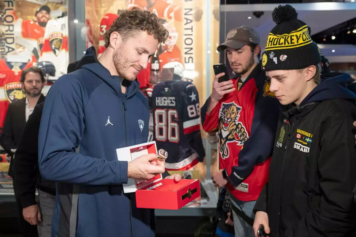 CORRECTS YEAR: Florida Panthers' Matthew Tkachuk shows fans the team's 2025 Stanley Cup ring before placing it inside the display at the Hockey Hall of Fame in Toronto, Canada, on Tuesday, Jan. 6, 2026. (Eduardo Lima/The Canadian Press via AP)