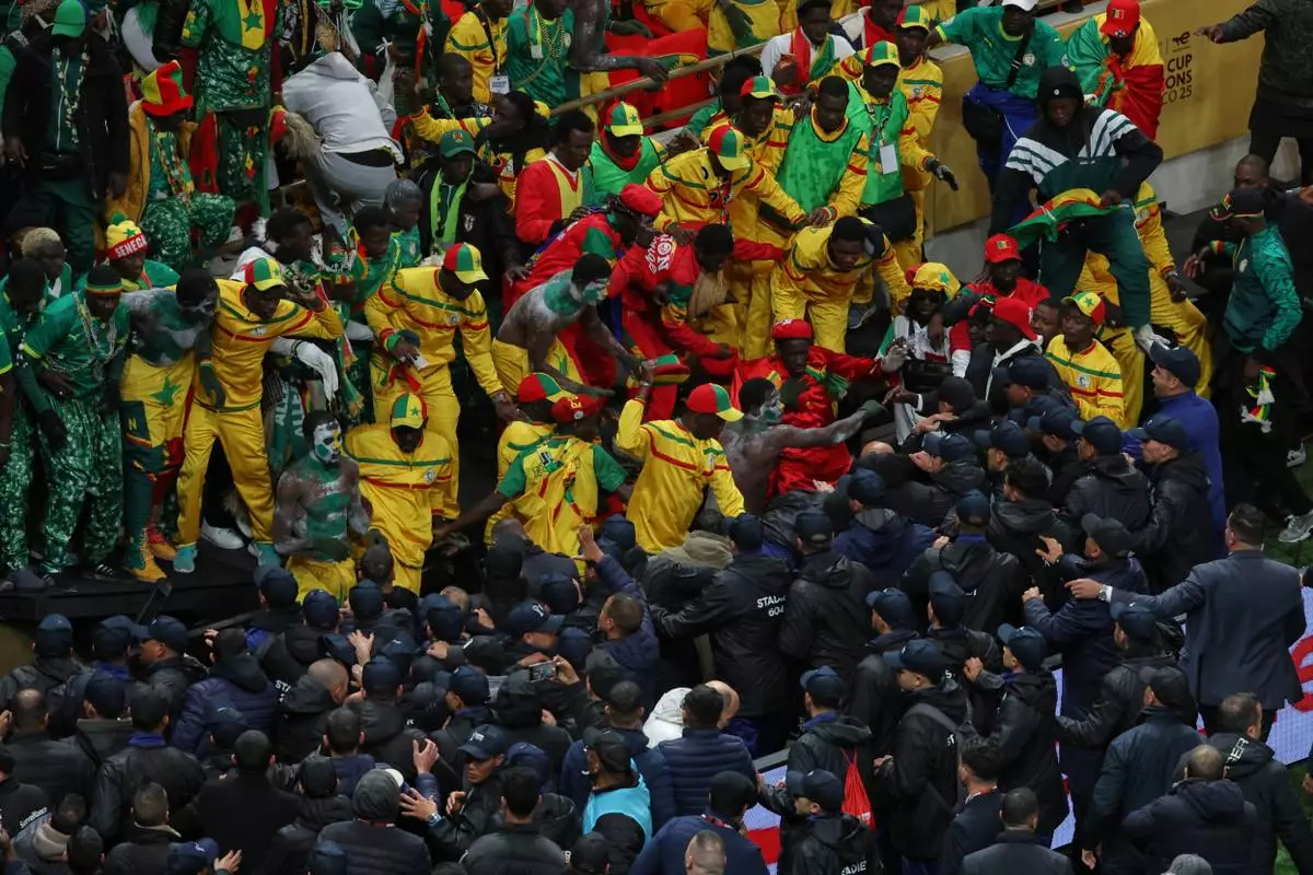 Senegal supporters clash with security services after a controversial penalty was awarded to Morocco late on during the Africa Cup of Nations final soccer match between Senegal and Morocco in Rabat, Morocco, Sunday, Jan. 18, 2026. (AP Photo/Youssef Loulidi)