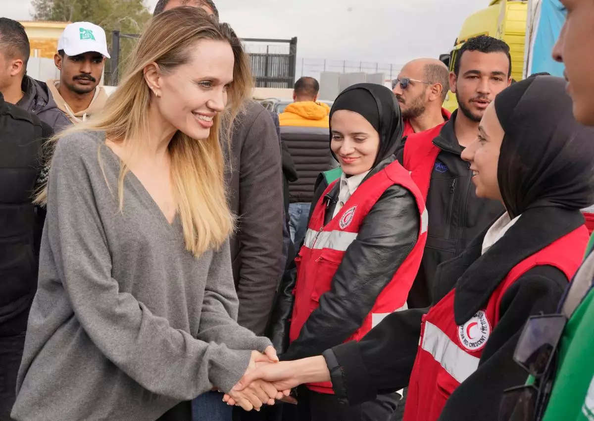 CORRECTS BYLINE TO EMAD ELGEBALY - American actor and film producer Angelina Jolie, front left, greets Red Crecent workers during her visit to the Rafah border crossing between Egypt and the Gaza Strip in Rafah, Egypt, Friday, Jan. 2, 2026. (AP Photo/Emad Elgebaly)