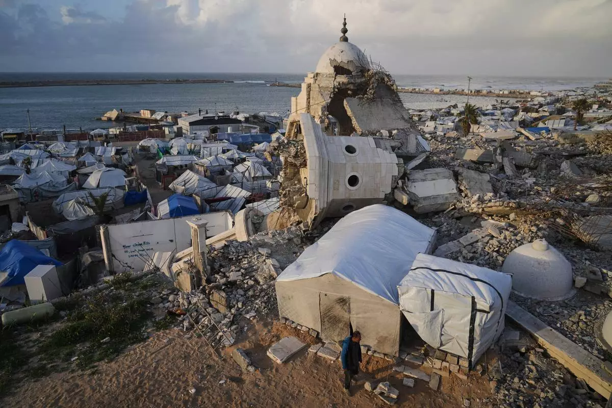 FILE - A man walks through tents sheltering displaced Palestinians amid the ruins left by the Israeli air and ground offensive in Gaza City, Wednesday, Jan. 28, 2026. (AP Photo/Jehad Alshrafi, File)