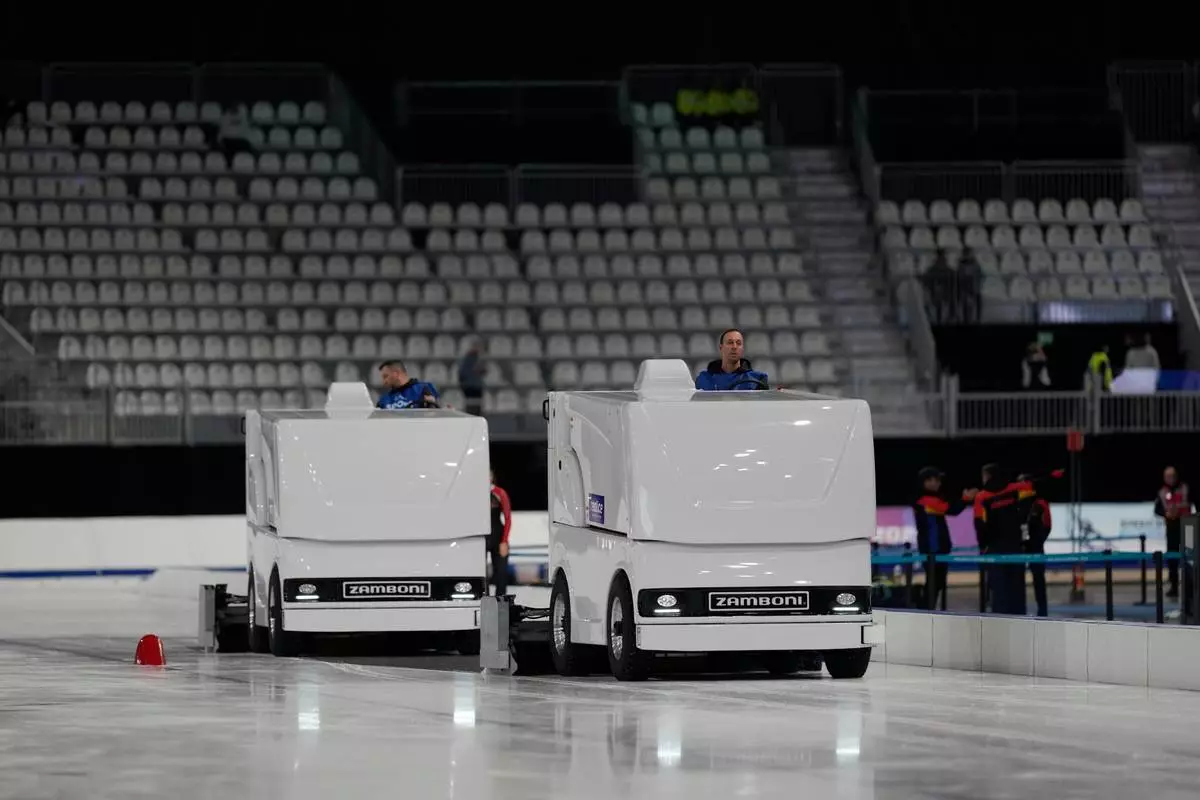 Workers clean the ice surface during a peed skating Junior World Cup and Olympic test event, in Rho, near Milan, Italy, Saturday, Nov. 29, 2025. (AP Photo/Luca Bruno)