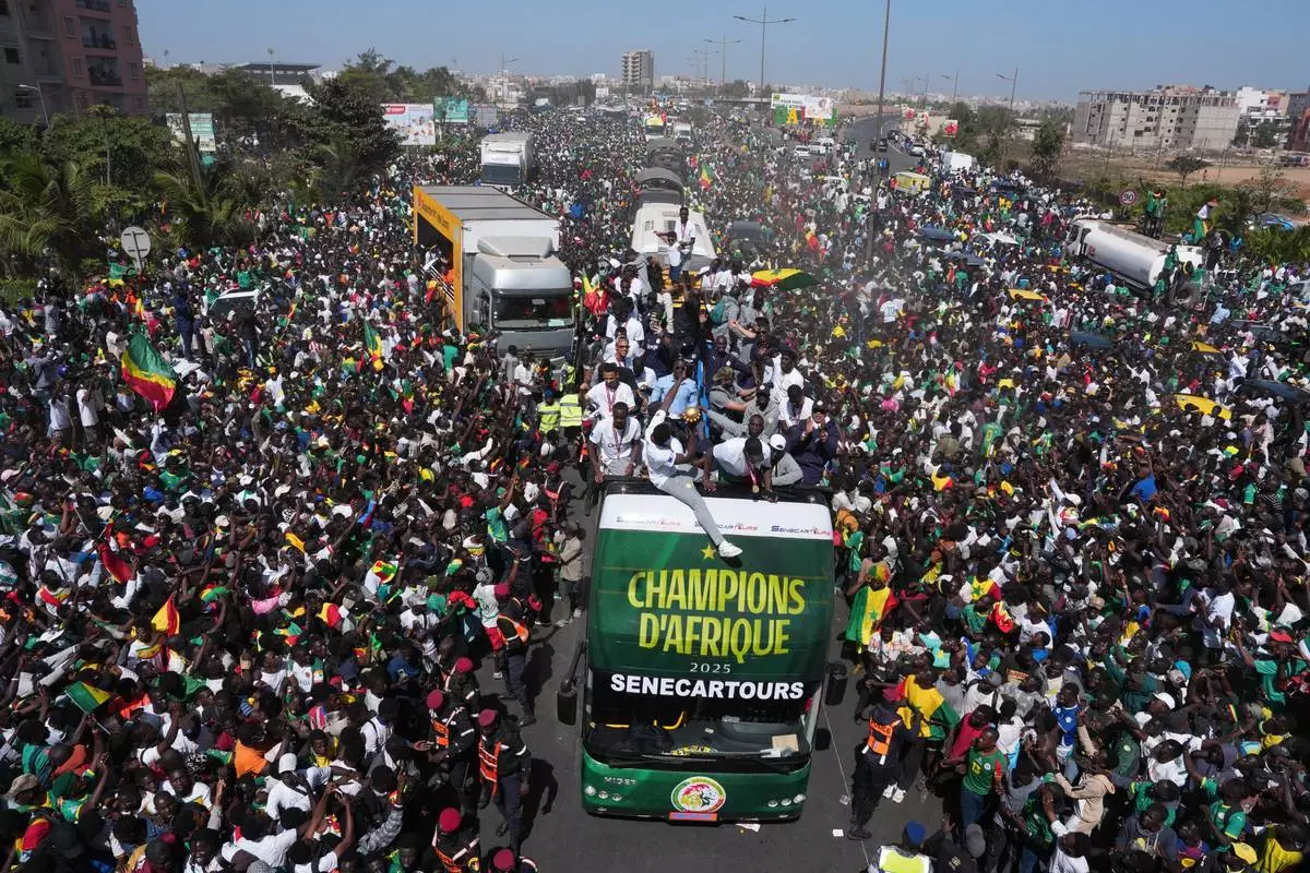 The Senegalese soccer team rides through thousands of cheering fans celebrating their victory in the Africa Cup of Nations soccer tournament, in Dakar, Senegal, Tuesday, Jan. 20, 2026. (AP Photo/Misper Apawu)